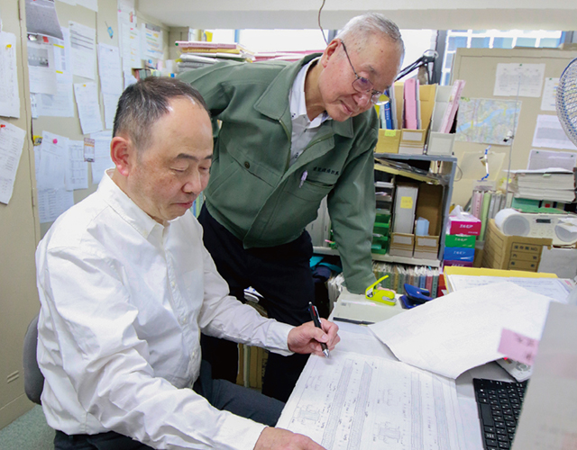 図面を確認する2人の社員